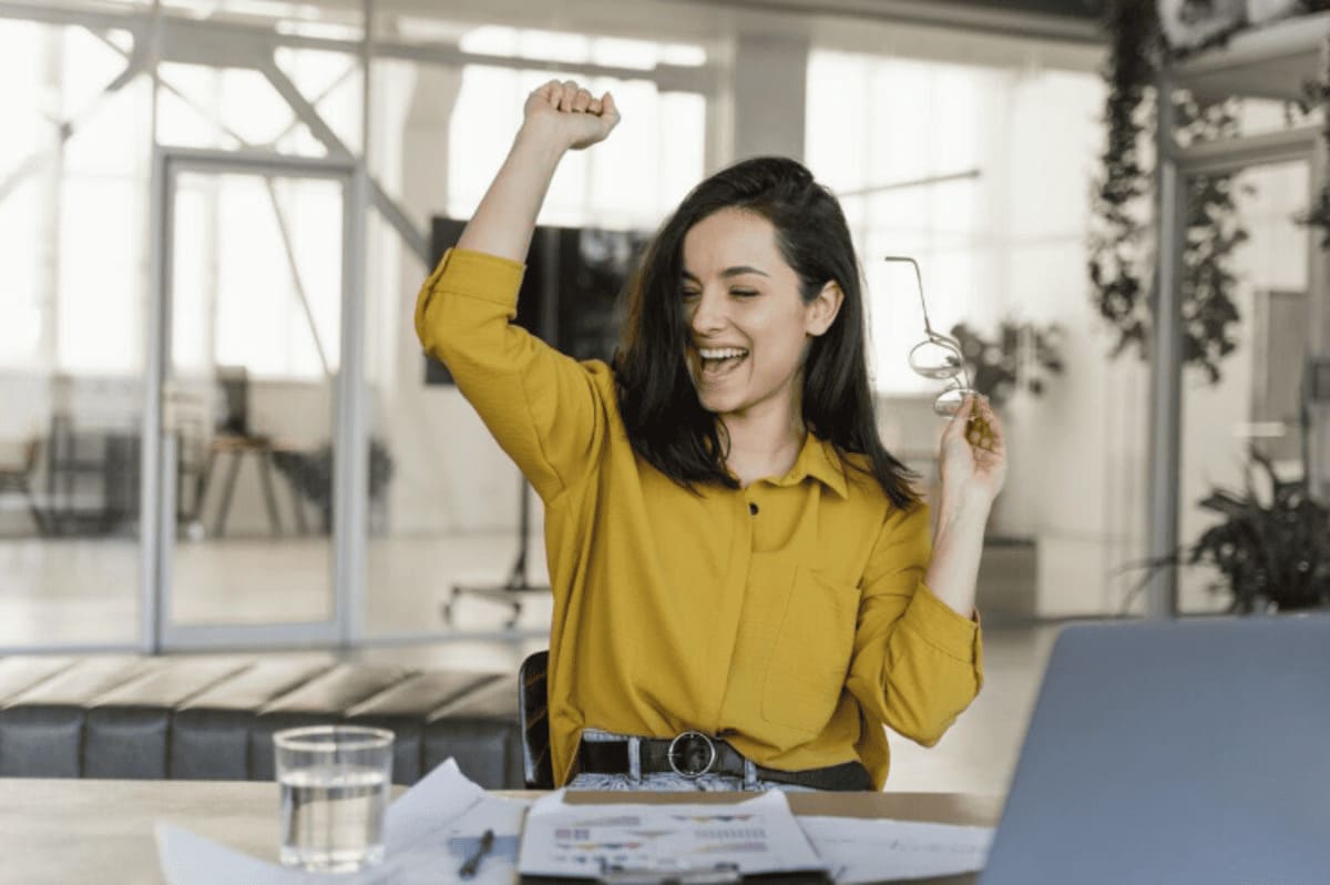 Foto de jovem no trabalho comemorando o recebimento do benefício flexível