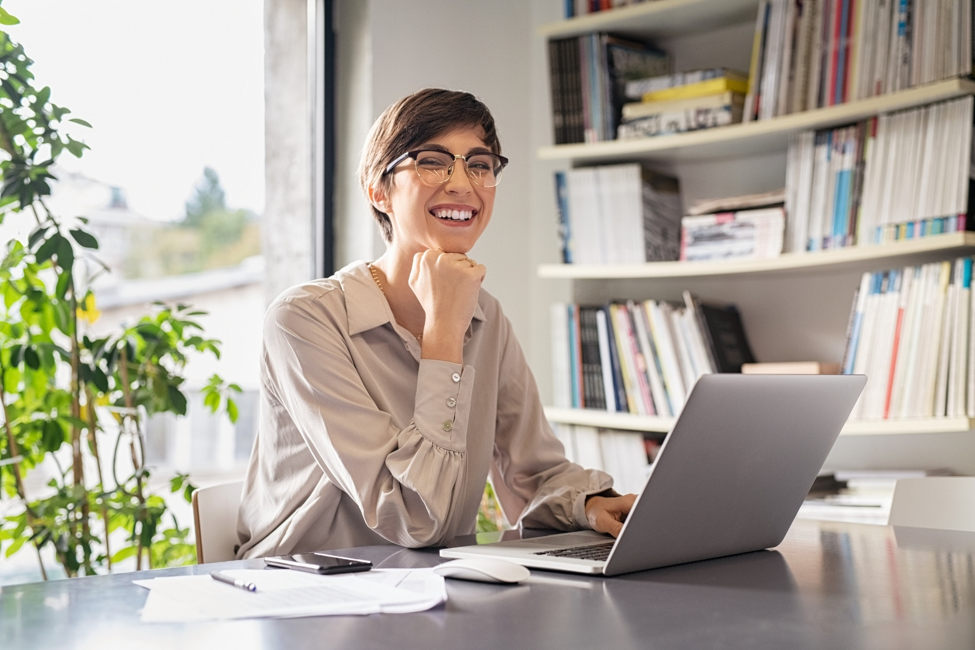 Mulher sorrindo e mexendo no computador.