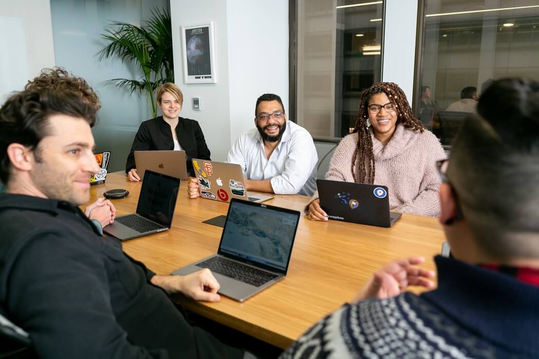 Equipe de trabalho contente reunida.