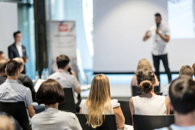 Líder em cima do palco, apresentando a premiação de fim de ano da empresa.