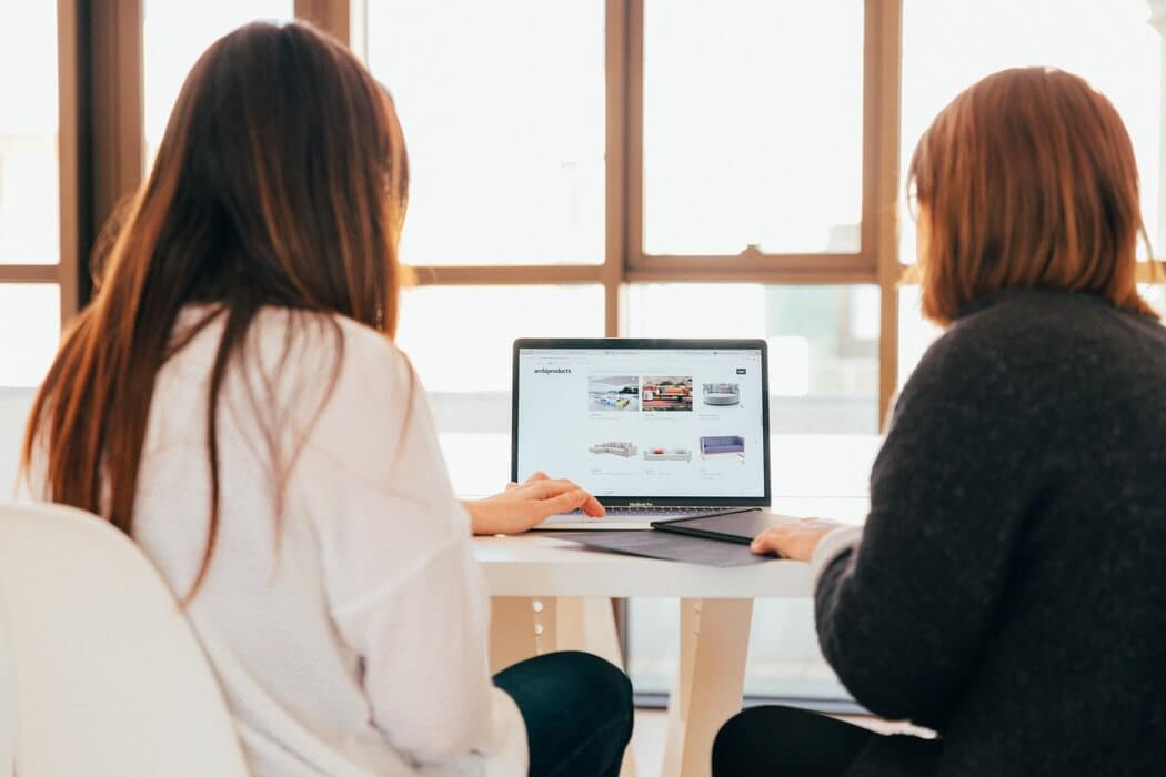 Dupla de mulheres mexendo em um programa de tecnologia do RH.