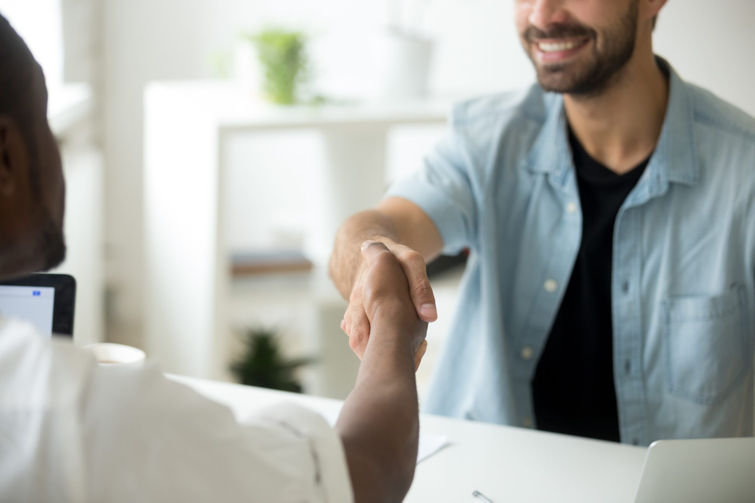 Pessoas no trabalho apertando as mãos e fechando acordo