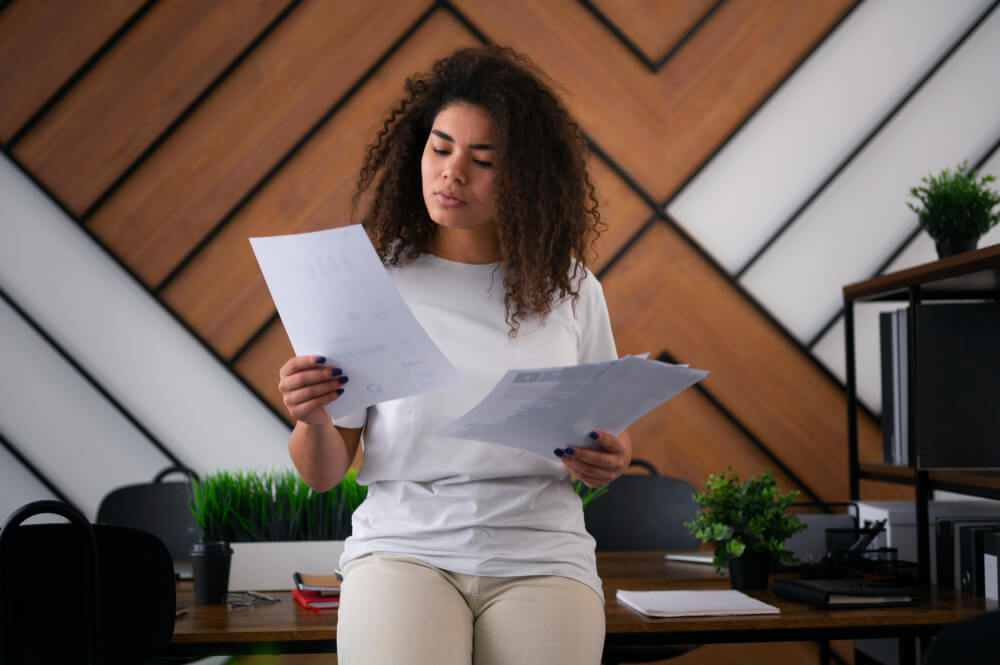 Mulher em um escritório com papeis na mão analisando a lei do empréstimo consignado para servidor públic