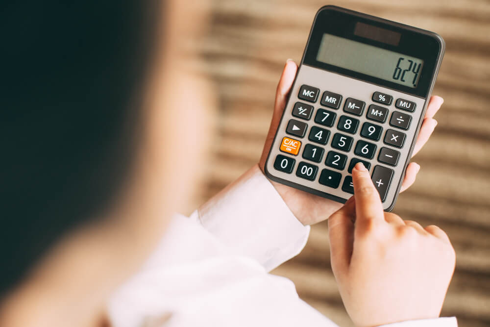 Pessoa utilizando calculadora para simular valores de crédito e verificar o limite da margem consignável disponível para empréstimo.
